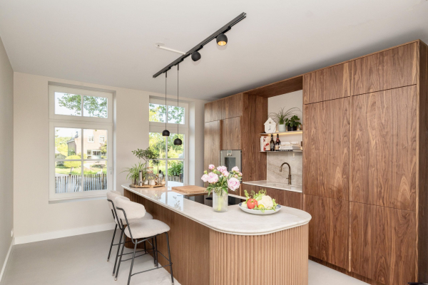 Houten keuken met kookeiland, afgeronde hoek en zitplaatsen